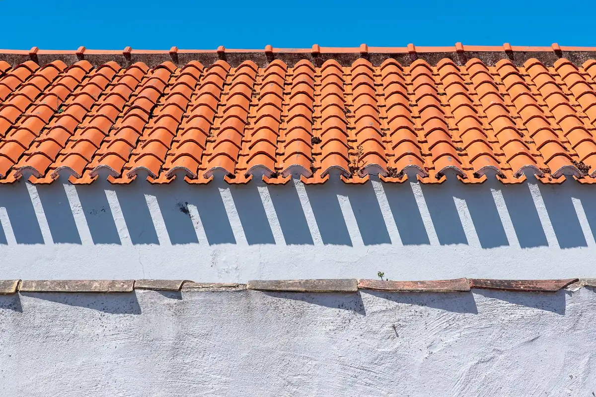 Clean orange barrel tile along the edge of a white stucco wall